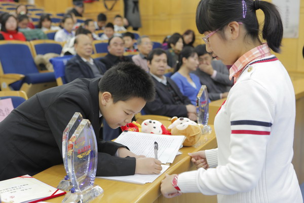 同学们在纷纷在李逸佳同学"以实际行动找回北京蓝天"倡议书上签名